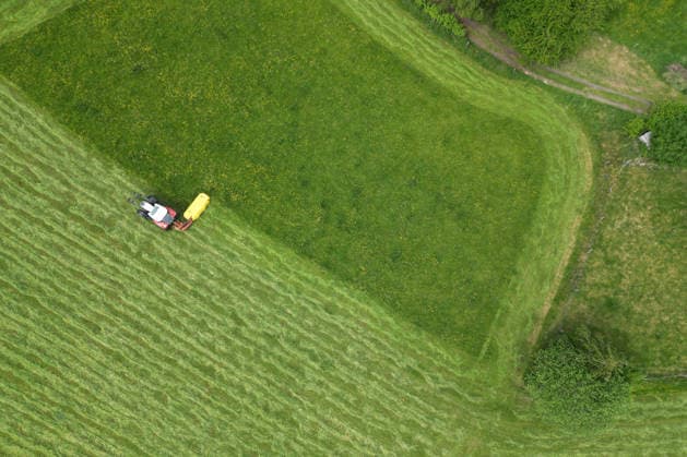 NRW, Traktor mäht Wiese im Siegerland