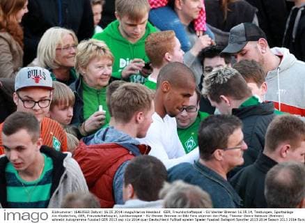GER, Freundschaftsspiel - SV Werder Bremen 16.05.14, Teistungen, Sportanlage Am Klosterholz, GER, Freundschaftsspiel, Jubiläumsspiel - SV Werder Bremen im Bild Fans stürmen den Platz, Theodor Gebre Selassie (Bremen) schreibt Autogramme
