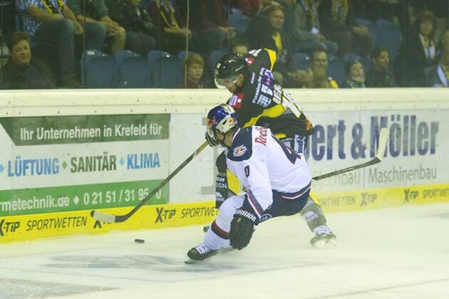 Krefeld, Deutschland 19. September 2014: 1. Bundesliga 14 15 - Krefeld Pinguine vs. EHC Red Bull Muenchen. Daniel Sparre (Muenchen) im Zweikampf gegen Adam Courchaine (Krefeld) ot