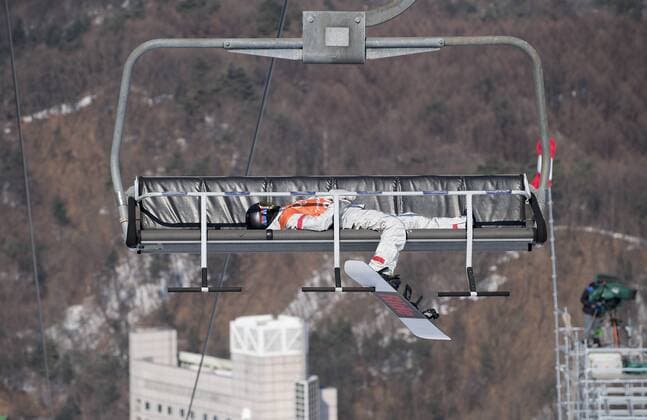 Themen der Woche - SPORT Bilder des Tages - SPORT Einer Snowboarderin liegt erschoepft (erschöpft) in einem Sessellift; allgemein, Feature; Snowboard Slopestyle Training Phoenix Snow Park am 08.02.2018, Olympische Winterspiele 2018, vom 09.02. - 25.02.2018 in PyeongChang Suedkorea.