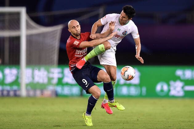 Bilder des Jahres 2020, Sport 08 August Sport Themen der Woche KW33 Sport Bilder des Tages Polish football player Adrian Mierzejewski of Chongqing SWM, left, falls on the ground after being kicked during the fourth-round match of 2020 Chinese Super League (CSL) against Qingdao Huanghai F.C., Suzhou city, east China s Jiangsu province, 11 August 2020. Qingdao Huanghai F.C. and Chongqing SWM drew the game with 0-0.
