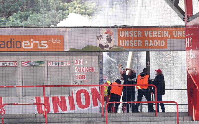 Bilder des Jahres 2021, Sport 04 April Sport Themen der Woche KW13 Sport Bilder des Tages Fussball, Herren, Saison 2020 2021, 1. Bundesliga (27. Spieltag), 1. FC Union Berlin - Hertha BSC, nach dem Zünden eines Feuerwerks brennt das Dach einer Imbissbude auf der Waldseite, Ordner versuchen, das Feuer zu löschen, 04.04. 2021, Copyright: xMatthiasxKochx