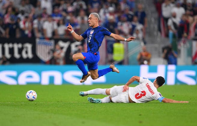 FUSSBALL WM 2022 VORRUNDE GRUPPE B Iran - USA 29.11.2022 Sergino Dest (li, USA) und Ehsan Hajsafi (re, Iran) verdienen sich im Zweikampf beste Haltungsnoten