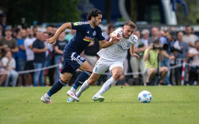 Fussball, Saison 2024 2025, Niederrheinpokal 20.08.2023, 01. Runde, Herren, BW Dingden (weiss) vs. MSV Duisburg (schwarz) v.l.: Mert Goeckan (MSV Duisburg), Lasse Hoffmann (BW Dingden), Hamminkeln Sportanlage BW Dingden Nordrhein-Westfalen Deutschland