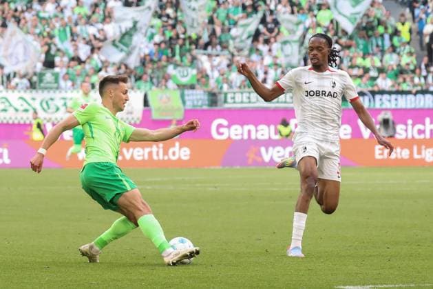 26.04.2025, xgox, Fussball 1.Bundesliga, VfL Wolfsburg - SC Freiburg emspor, v.l. Kilian Fischer (Wolfsburg, 2), Junior Adamu (SC Freiburg, 20) Zweikampf, Duell, Kampf, tackle (DFL DFB REGULATIONS PROHIBIT ANY USE OF PHOTOGRAPHS as IMAGE SEQUENCES and or QUASI-VIDEO) Wolfsburg