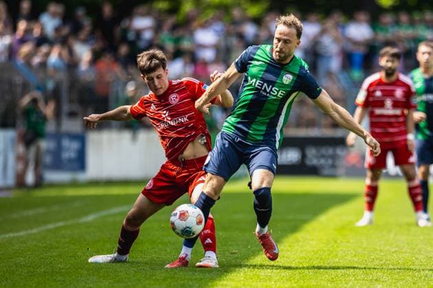 09.08.2025, xkwix, Fußball, Regionalliga West, FC Gütersloh - Fortuna Düsseldorf 2, Ohlendorf Stadion im Heidewald: Julius Langfeld ( FC Gütersloh 10 ) im Zweikampf gegen Leo Mirgartz (Fortuna Düsseldorf II 17) NRW Deutschland