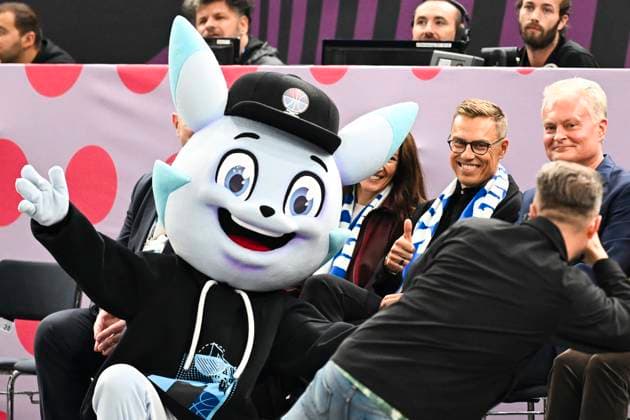 Finland s President Alexander Stubb and his wife Suzanne Innes-Stubb, right, with the mascot courtside before the match between Finland and Lithuania in the European Basketball Championship at Nokia Arena in Tampere, Finland on September 1 2025. TAMMERFORS FINLAND x10070x