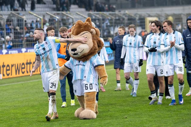 Das Team TSV 1860 Muenchen kommt zu den Fans, Patrick Hobsch 34 (TSV 1860 Muenchen) haelt dem Maskotchen das Auge zu, TSV 1860 Muenchen vs. Rot-Weiss Essen, 3. Liga, 20. Spieltag, 17.01.2026 DFB regulations prohibit any use of photographs as image sequences and or quasi-video Muenchen Bayern Deutschland