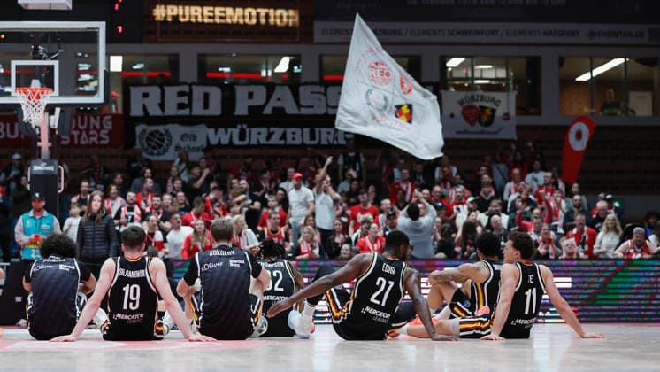 Im Bild: Die Spieler der Wuerzburg Baskets setzen sich nach dem Sieg auf den Boden und feiern mit ihren Fans. 11.02.2026, Fitness First Wuerzburg Baskets vs. Unicaja Malaga, Basketball Champions League, Round of 16, Group K, 4. Spieltag, Deutschland, 97072, tectake-Arena Wuerzburg, Copyright: HMBxMedia xJulienxBecker