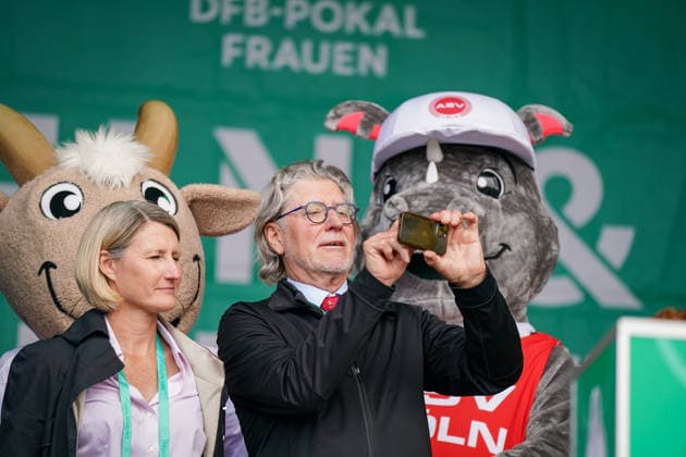 Deutschland: Fussball DFB Pokal Frauen 2025 - 2026, Finale - VfL Wolfsburg vs FC Bayern München - Rhein-Energie-Stadion (Köln): Toni Schumacher, FC-Legende, Torwartlegende, deutscher Fussball, Nationaltorwart, ehemaliger Nationalspieler, DFB, Fanfest, Bühne, DFB-Pokal-Trophäe, Pokalpräsentation, Frauenfussball, VfL Wolfsburg, FC Bayern München Frauen, Maskottchen, Zuschauer, Fans, Eventbühne, Sportevent, Medienevent, Fussball-Atmosphäre, Public Event Copyright: xJOERANxSTEINSIEKx