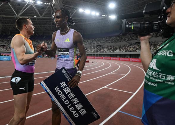 Wanda Diamond League 2026 - Shanghai Keqiao SHAOXING, CHINA - MAY 16: Alison dos Santos of Brazil shakes hands and shares a moment with rival Karsten Warholm of Norway while holding a World Lead sign after winning the men s 300m hurdles race during the Yangtze River Delta Athletics Diamond Gala, the Shanghai Keqiao leg and opening meeting of the 2026 Wanda Diamond League circuit, at the China Textile City Sports Center in Keqiao, Shaoxing, Zhejiang province, China, on May 16, 2026. Artur Widak Anadolu Shaoxing China. Editorial use only. Please get in touch for any other usage.  Copyright: x2026xAnadoluxArturxWidakx