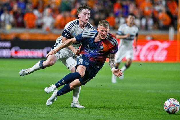 May 16, 2026: Houston Dynamo midfielder Mateusz Bogusz (right) is held back by Vancouver Whitecaps defender Tate Johnson (left) during the first half of a MLS, Fussball Herren, USA game at Shell Energy Stadium in Houston, TX. Austin McAfee CSM Houston USA - ZUMAc04_ 20260516_zma_c04_043 Copyright: xAustinxMcafeex