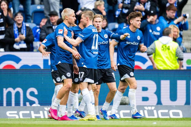 17.05.2026 - Fußball, 2025 2026, 2. Bundesliga, 34. Spieltag, DSC Arminia Bielefeld - Hertha BSC Berlin: (L-R) Joel Grodowski (Bielefeld) jubelt nach seinem Tor zum 1:1 in einer Jubeltraube mit Arne Sicker (Bielefeld), Sam Schreck (Bielefeld), Maximilian Großer (Bielefeld) DFL REGULATIONS PROHIBIT ANY USE OF PHOTOGRAPHS AS IMAGE SEQUENCES AND OR QUASI-VIDEO.
