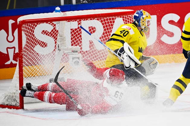 FRIBOURG, SCHWEIZ 20260517 Danmarks Christian Wejse aker in i det svenska malet vid Sveriges malvakt Arvid Söderblom under söndagens match i ishockey-VM mellan Danmark och Sverige pa BCF Arena, Fribourg i Schweiz.