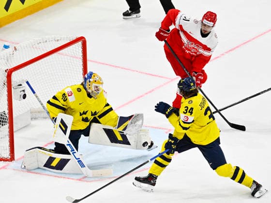 FRIBOURG, SCHWEIZ 20260517 Sveriges malvakt Arvid Söderblom räddar pucken, Albert Johansson och Danmarks Alexander True star bredvid under söndagens match i ishockey-VM mellan Danmark och Sverige pa BCF Arena, Fribourg i Schweiz.