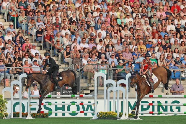 Richard Vogel und Luciana Diniz im Tempo gemeinsam in Bond-Stunt-Feeling über die Hindernisse, Konzert Pferd & Sinfonie, Rahmenprogramm, Motto des Abends: James Bond, Weltfest des Pferdesports, World Equestrian Festival, TSCHIO Aachen 2026, TSCHIO statt CHIO 2026, Aachener Soers, 22. bis 24. Mai 2026, Reitsport, 23.05.2026, Aachen Aachener Soers Deutschland