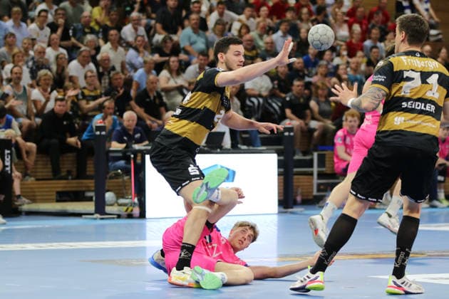 25.05.2026 Handball Herren 2025 2026 2. Handball-Bundesliga 32. Spieltag HC Elbflorenz 2006 - TSV Bayer Dormagen BallsportArena Dresden Florian Boehnert (Dormagen, 9, pink) liegt am Boden. Ediz Aktas (Dresden, 21, schwarzgold) spielt den Ball zu Oliver Seidler (Dresden, 71, schwarzgold). Dresden Sachsen Deutschland