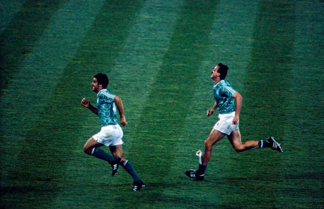 WM 1990 - Halbfinale - BRD vs England WM 1990 in Italien, Stadio delle Alpi in Turin, Halbfinale: BRD vs England 1:1 n.V. (4:3 i.E.). Jürgen Kohler läuft mit einem Mitspieler glücklich durch das Spielfeld. Turin - Copyright: xUnitedxArchivesx xSvenxSimonxSportx SVS_95020001190