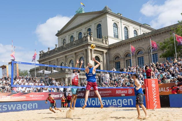 Deutsche Meisterschaften im Beach-Volleyball. 2026 Manuel Harms (Kiel) schlägt gegen den Block von Valentin Schneckenburger (München). Deutsche Meisterschaften im Beach-Volleyball am 24. Juli 2026 in Hannover. Viertelfinalspiel der Männer zwischen dem 1. Beachclub Kiel und Beachvolley United München., Hannover Niedersachsen Deutschland Opernplatz