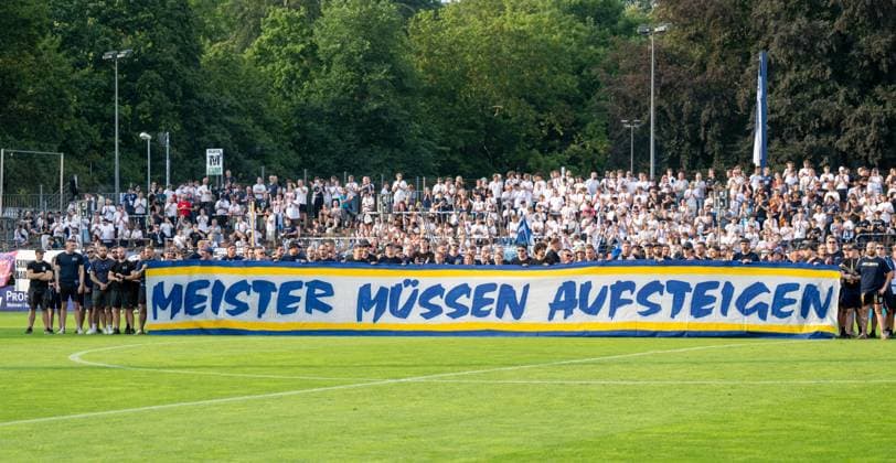 Sport Bilder des Tages Fussball, Herren, Saison 2026 2027, Regionalliga Nordost (2. Spieltag), SV Babelsberg 03 - FC Carl Zeiss Jena, Fans von Jena (im Bild) und Babelsberg demonstrierten vor dem Spiel für eine Aufstiegsreform für die Regionalligen, Meister müssen aufsteigen, Kompassmodell jetzt !, 31.07. 2026, Copyright: xMatthiasxKochx