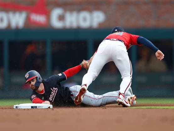 Right fielder Dylan Crews 3 of the Washington Nationals slides around the tag of shortstop Jim Jarvis 74 of the Atlanta Braves in the first inning at Truist Park on Friday, July 31, 2026 in Atlanta, Georgia.  ATL20260731102 MikexZarrilli