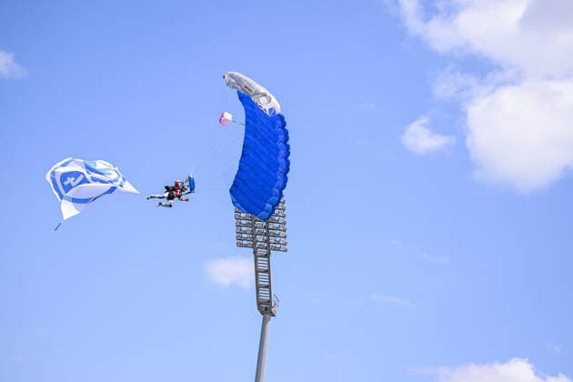 01.08.2026, Fussball, Saison 2026 2027, Testspiel, KSV Hessen Kassel - FC Schalke 04, Fallschirmspringer landet mit Schalke Fahne auf dem Rasen xRHR-FOTO YYx Copyright: KROEGER RHR-FOTOx RHR-FOTO YY