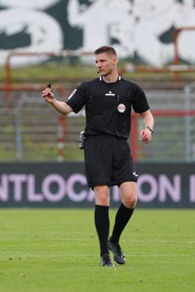 01.08.26, GER, Regionalliga Nord, Fussball, 1. Spieltag, Saison 2026 2027, Dietmar-Scholze-Stadion an der Lohmuehle, VfB Luebeck vs SC Weiche Flensburg Einzelaktion Aktion Ganze Figur Einzeln Freisteller Schiedsrichter Kevin Behrens Foto nordphoto GmbH Tauchnitz Luebeck Dietmar-Scholze-Stadion an der Lohmuehle SH Germany Copyright: xnordphotoxGmbHx xTauchnitzx