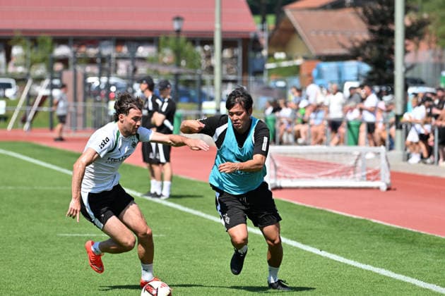 04.08.2026; Rottach-Egern; Fussball, Herren, Saison 2026 2027, Trainingslager Borussia Moenchengladbach Bei Gladbach spielt auch der Dolmetscher im Training mit. Hier Dolmetscher Atsushi Waki, re. Im Zweikampf mit Joe Scally (Gladbach, li.) DFL regulations prohibit any use of photographs as image sequences and or quasi-video. Stadion Am Birkenmoos Bayern Deutschland