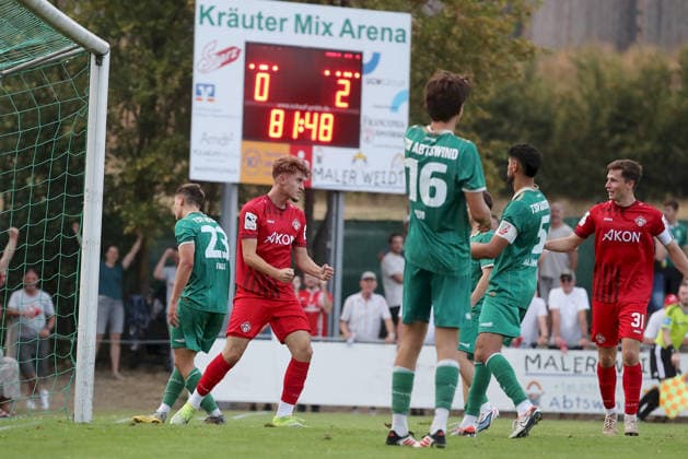 04.08.2026, xfsx, Herren, Fussball, Saison 2026 2027, BFV Verbandspokal, 2. Runde: TSV Abtswind - FC Wuerzburger Kickers v.li.: Patrick Falk (TSV Abtswind), Tiago de Moura Moraes (FC Wuerzburger Kickers) mit Torjubel, celebrate the goal, goal celebration, Jubel ueber das Tor zum 0:3, Nils Kuss (TSV Abtswind), Osama Alawami (TSV Abtswind), Tim Kraus (FC Wuerzburger Kickers) Abtswind Kraeuter Mix Arena Kitzingen Deutschland