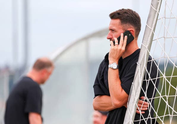 07.08.2026, Deutschland, Grassau, Fußball Bundesliga, Saison 2026 2027, Trainingslager VfB Stuttgart, Sportdirektor Christian Gentner am Telefon, Handy