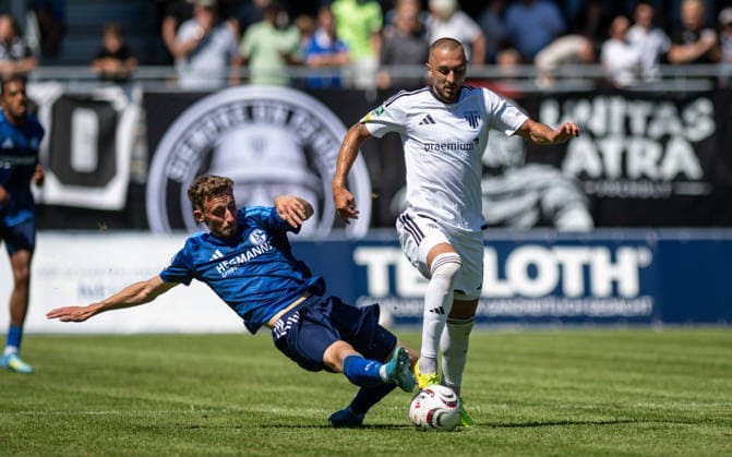 Fussball, Saison 2026 2027, Regionalliga West, 08.08.2026, 02. Spieltag, Herren, 1.FC Bocholt (weiss) vs. FC Schalke 04 U23 (blau) v.l.: Felix Christian Meyer (FC Schalke 04 U23), Stipe Batarilo (1.FC Bocholt), Bocholt Stadion am Huenting Deutschland