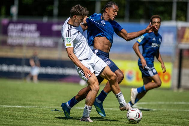 Fussball, Saison 2026 2027, Regionalliga West, 08.08.2026, 02. Spieltag, Herren, 1.FC Bocholt (weiss) vs. FC Schalke 04 U23 (blau) v.l.: Benjamin Friesen (1.FC Bocholt), Anton Leander Donkor (FC Schalke 04 U23), Bocholt Stadion am Huenting Deutschland