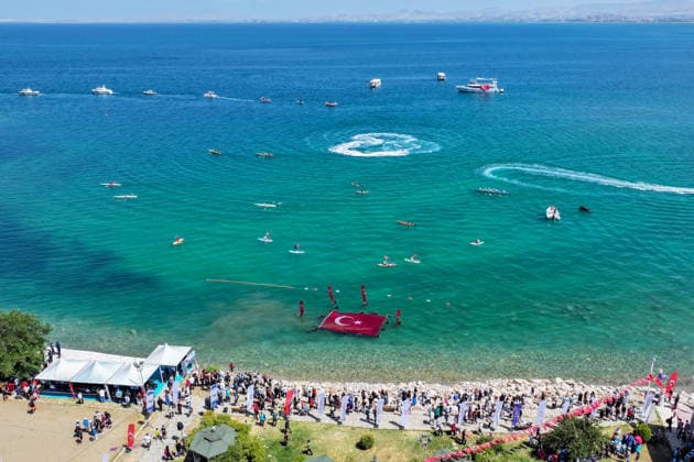 12th Van Sea Water Sports Festival kicks off on Lake Van VAN, TURKIYE - AUGUST 08: An aerial view of divers unfurling a large Turkish flag as participants and athletes taking part in the 12th Van Sea Water Sports Festival held at the Edremit-Gebze Water Sports Center on the shores of Lake Van in Van, Turkiye, on August 08, 2026. Organized to promote Lake Van and boost local tourism, the two-day event features Beach volleyball, Beachvolleyball and handball matches, flyboard demonstrations, canoeing, rowing, dragon boat races, and various recreational activities. Ozkan Bilgin Anadolu Van Turkey. Editorial use only. Please get in touch for any other usage. Copyright: x2026xAnadoluxOzkanxBilginx