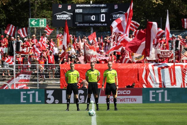 08.08.2026, xsefx, Fußball, FC Viktoria Köln SSV Jahn Regensburg, 3.Liga, Sportpark Höhenberg, 1. Spieltag, Saison 2026 2027: Die Spielleiter Lennart Kernchen, Julian Bergmann (rechts) und Mika Jungclaus (links) während der Schweigminute für Günter Pütz, den ehemaligen Präsident des FC Viktoria Köln 1904 e.V. DFB regulations prohibit any use of photographs as image sequences and or quasi-video. Nordrhein-Westfalen Deutschland