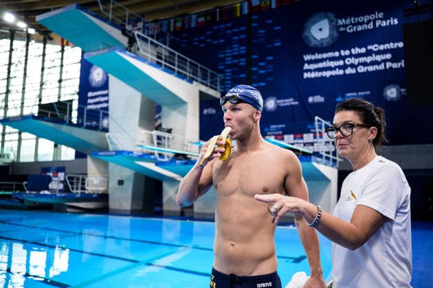 260809 Victor Johansson of Sweden eating a banana and head coach Martina Aronsson at a swimming training session during day ten of the 2026 European Aquatics Championships on August 9, 2026 in Saint-Denis. Photo: Joel Marklund BILDBYRAN kod JM JM0836 bbeng simning swimming svomming 2026 european aquatics championships em träning training practice Sverige Sweden banan Copyright: JOELxMARKLUND BB260809JM028
