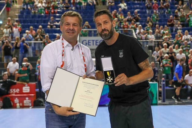 11.08.2026, xgox, Handball - Hummel Cup 2026 SC Magdeburg - GWD Mindenemspor, v.l. Bennet Wiegert (Magdeburg, Trainer) bekommt den Verdienstorden für das Land Sachsen-Anhalt von Minsterpräsident Sven Schulze Magdeburg