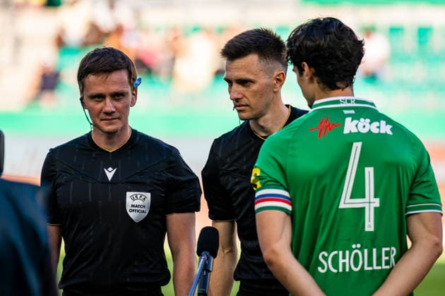 SOCCER - UEFA ECL, Rapid vs Paide VIENNA,AUSTRIA,12.AUG.26 - SOCCER - UEFA Conference League, qualification, SK Rapid Wien vs Paide Linnameeskond. Image shows referee Denys Shurman (UKR) and Jakob Schoeller (Rapid) during coin toss.  GEPAxpictures xKevinxHackner