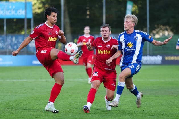12.08.2026, Fussball, Herren, Regionalliga Nord, 16. Spieltag, FC Eintracht Norderstedt - BSV Kickers Emden Bent Andresen (blau 15 BSV Kickers Emden) im Zweikampf mit Fabian Grau (links 4 FC Eintracht Norderstedt) und Leon Pesch (18 FC Eintracht Norderstedt)