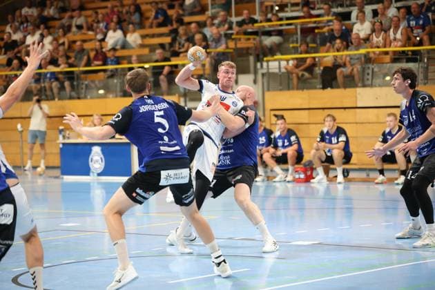 Ole Hagedorn ( 10; VfL Lübeck-Schwartau) kämpft sich mit dem Ball in der Hand durch zwei Abwehrspieler von Grindstedt GIF. Der Spieler mit 5 (Jørgensen) auf dem Rücken versucht den Durchbruch zu stoppen, während Hagedorn zum Wurf ansetzt. Ole Hagedorn ( 10; VfL Lübeck-Schwartau) im Durchbruch gegen Grindstedt GIF