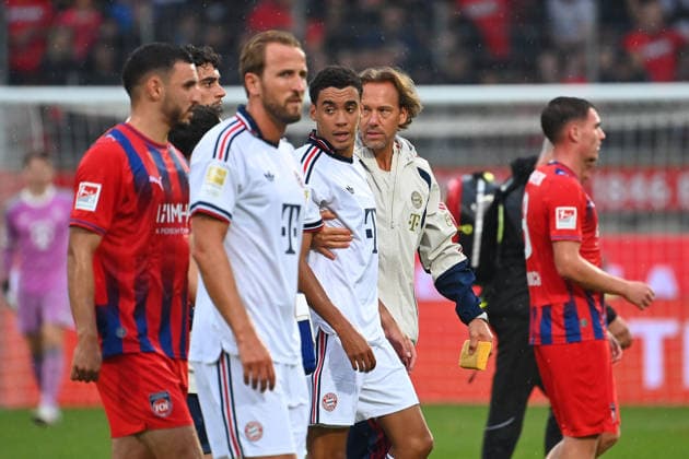 Jamal MUSIALA (Bayern Muenchen) bricht erneut zusammen,Ohnmacht, wird von Dr.Peter UEBLACKER (Mannschaftsarzt FCB) vom Platz gefuehrt, li:Harry KANE (Bayern Muenchen). Fussball Testpiel 1.FC Heidenheim - FC Bayern Muenchen am 18.08.2025 , VOITH ARENA.