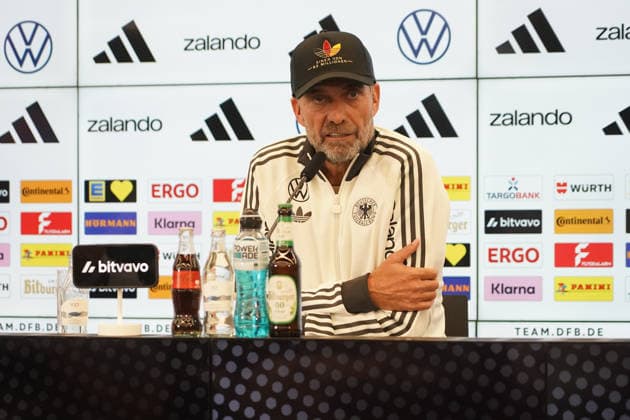 Bundestrainer Jürgen Klopp kommt zur Pressekonferenz zur ersten Kadernominierung der Nationalmannschaft mit einer Kappe Einer von 83 Millionen - 17.09.2026: Erste DFB-Kadernominierung von Bundestrainer Jürgen Klopp, DFB-Campus Frankfurt