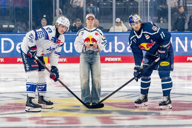 Die Red Bull - Athletin Lilou Ruel fuehrte mit Marc Michaelis (Adler Mannheim, 65) und Markus Eisenschmid (EHC Red Bull Muenchen, 11) das Anbully aus, nachdem sie vorher mit einem Sprung vom Videwuerfel den Puck auf das Eis gebracht hatte GER, EHC Red Bull Muenchen vs. Adler Mannheim, Eishockey, DEL, Saison 2026 2027, 1. Spieltag, 18.09.2026. Foto: HMB Media Heike Feiner Copyright: HMBxMedia HeikexFeiner
