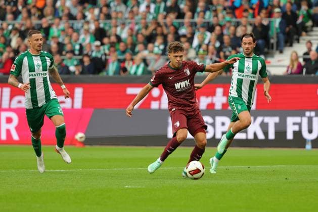 19.09.26, GER, Fussball, 1.FBL Männer, 4. Spieltag, Saison2026 2027, SV Werder Bremen vs. FC Augsburg Tor zum 0:1. Torschütze Torschuetze Robin Fellhauer (FC Augsburg 19) trifft zum 0:1 ins Tor von Torwart Karl Hein (SV Werder Bremen 01) , keine Chance für Marco Friedl (SV Werder Bremen 32) und Olivier Deman (SV Werder Bremen 02) Bremen Weserstadion Bremen Germany Copyright: xnordphotoxGmbHx xTauchnitzx