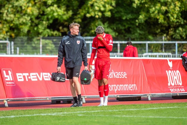 Colin Kroll-Thiel (re.) mit Physio des GFCs. Der Stürmer musste kurz nach seiner Einwechslung verletzungsbedingt wieder aus dem Spiel genommen werden. GER, Fussball, Herren, Regionalliga Nordost, Saison 2026-2027, 9. Spieltag, Greifswalder FC - FSV 63 Luckenwalde