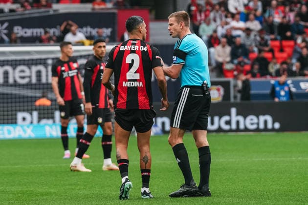 20.09.2026, xjmrgnx, Fussball 1.Bundesliga, Bayer 04 Leverkusen - RB Leipzig v.l. Facundo Medina (2, Leverkusen) im intensiven Gespräch mit Schiedsrichter Robert Schröder (DFL DFB REGULATIONS PROHIBIT ANY USE OF PHOTOGRAPHS as IMAGE SEQUENCES and or QUASI-VIDEO) Leverkusen