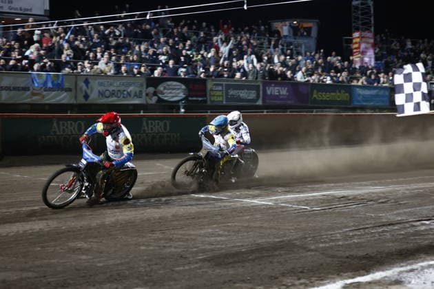 VÄSTERVIK, SVERIGE 20260922 Västerviks Max Fricke och Rohan Tungate slass mot Dackarnas Andreas Lyager pa mallinjen i heat 16 under tisdagens avgörande SM-final i speedway mellan Västervik och Dackarna pa Hejla Arena i Västervik. VÄSTERVIK SVERIGE x60160x