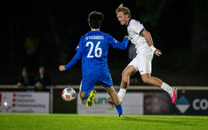 Fussball, Saison 2026 2027, Niederrheinpokal, 23.09.2026, 02. Runde, Herren, BW Dingden (weiss) vs. SF Baumberg (blau) v.l.: Millan Burovac (SF Baumberg), Joshua Mueller (BW Dingden), Hamminkeln Sportplatz BW Dingden Deutschland