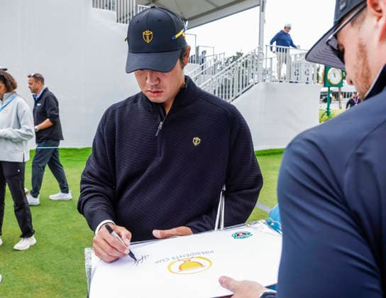 International team member Hideki Matsuyama of Japan signs an autograph for a fan by the fifteenth green during practice for the Presidents Cup golf tournament at Medinah Country Club in Medinah, Illinois on Wednesday, September 23, 2026. Competition between the USA and the International team begins on Thursday, September 24 with Four-Ball play.  MED20260923805 TANNENxMAURY