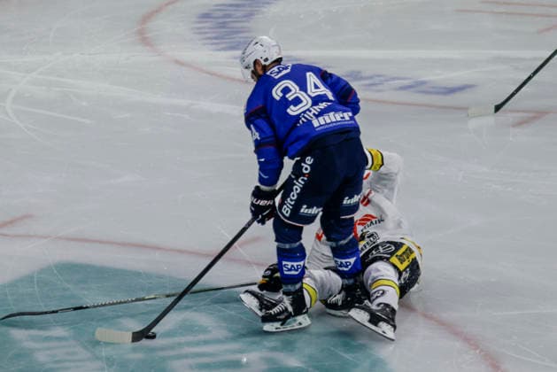 25.09.2026, xhettx, Eishockey Penny DEL, Adler Mannheim - Krefeld Pinguine v.l. Tom Kühnhackl (Adler Mannheim, 34) wird gelegt