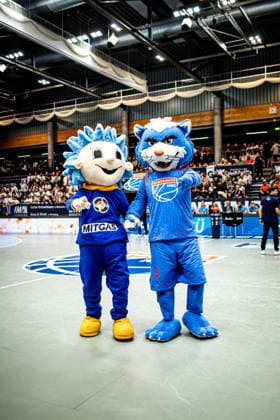 BB-1BL Herren Syntainics MBC - Science City Jena Mitgas und der Syntainics MBC Wolf waehrend der Saison 2026-2027 zum 2. Spieltag in der 1. EasyCredit Basketball Bundesliga zwischen Syntainics MBC und Science City Jena in der Stadthalle Weissenfels am 25. September 2026 in Weissenfels, Sachsen Anhalt, Deutschland